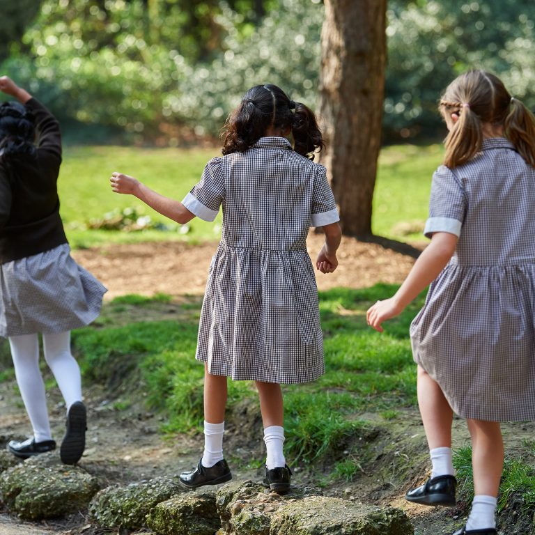 little girls walking on rocks