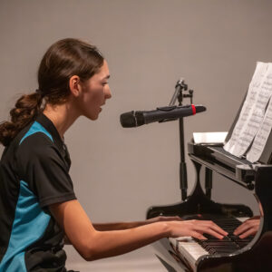 Student singing whilst playing the piano