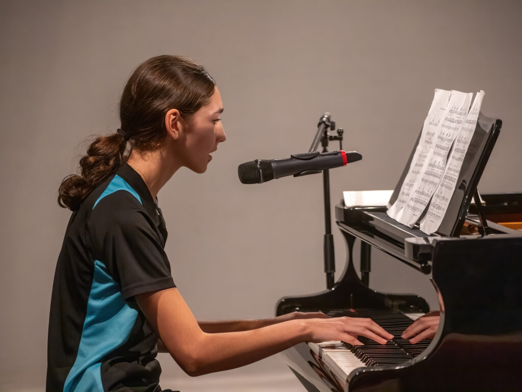 Student singing whilst playing the piano