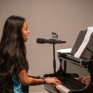 Student singing whilst playing the piano