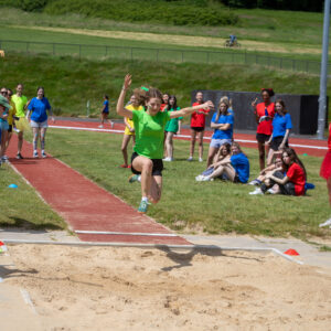 student doing a long jump
