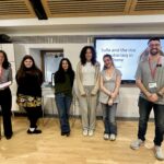 Group of six students standing in a classroom in front of a presentation screen displaying 'Sulla and the rise of autocracy in Rome'.