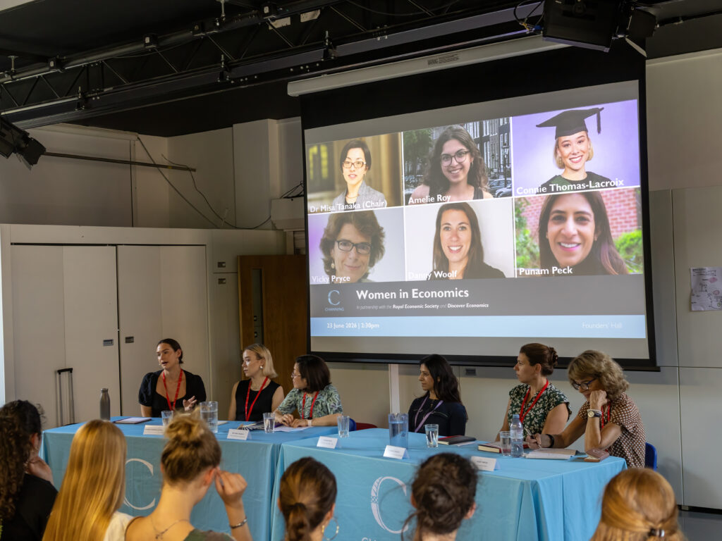 Conference room panel: projector screen shows a grid of female speakers for 'Women in Economics'.
