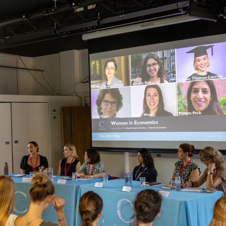 Conference room panel: projector screen shows a grid of female speakers for 'Women in Economics'.